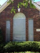 An older style center arched window. This one has single-hung windows with solar screens.