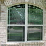 Arch top single hung windows with modified prairie style grids.